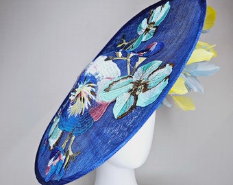 kentucky derby hat fascinator blue sinamay saucer with yellow and light blue feathers and blue blue white pink yellow embroidered flowers