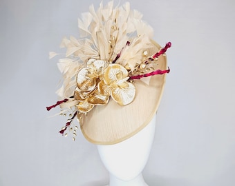 kentucky derby hat fascinator gold taupe beige shantung silk saucer with curls and gold orchids and light tan feathers with burgundy stems