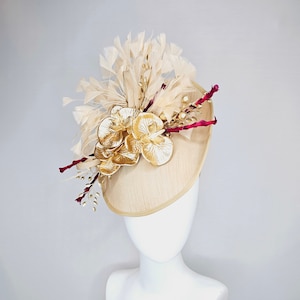 kentucky derby hat fascinator gold taupe beige shantung silk saucer with curls and gold orchids and light tan feathers with burgundy stems
