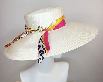kentucky derby hat wide brim white sheen dressy fedora hat with downsloping brim gold horsebit colorful equestrian pink black leopard scarf