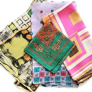 May include: A collection of colorful silk scarves with various patterns. The scarves include geometric, floral, and abstract designs in shades of green, pink, orange, and blue. A measuring tape is at the bottom of the image.