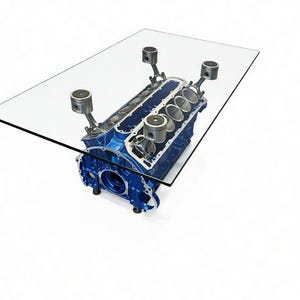 May include: A rectangular glass-top coffee table with a blue engine block base. The engine block has silver pistons and connecting rods. The table is a unique piece of furniture.