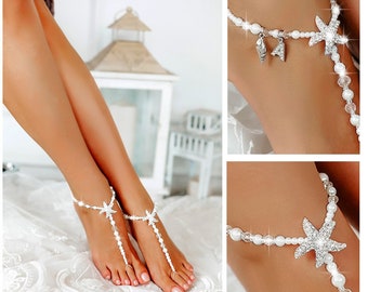 Op de afbeelding: Witte parel en kristal voetsieraden met zeester en schelp bedels. De sieraden zijn delicaat en vrouwelijk, perfect voor een strandbruiloft of een zomerfeest.