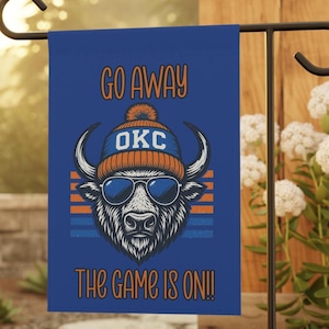 May include: A blue garden flag with the text "GO AWAY" and "THE GAME IS ON!!". The flag features a graphic of a bull wearing sunglasses and a beanie with "OKC" on it. The bull is set against orange and blue stripes.