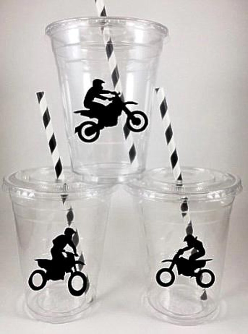 K&ouml;nnte beinhalten: Drei durchsichtige Plastikbecher mit schwarz-wei&szlig; gestreiften Strohhalmen. Jeder Becher hat eine schwarze Silhouette eines Motocross-Fahrers auf einem Dirtbike.