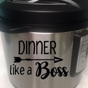 May include: A stainless steel Instant Pot with a black vinyl sticker that reads "Dinner like a Boss" with an arrow pointing to the right.