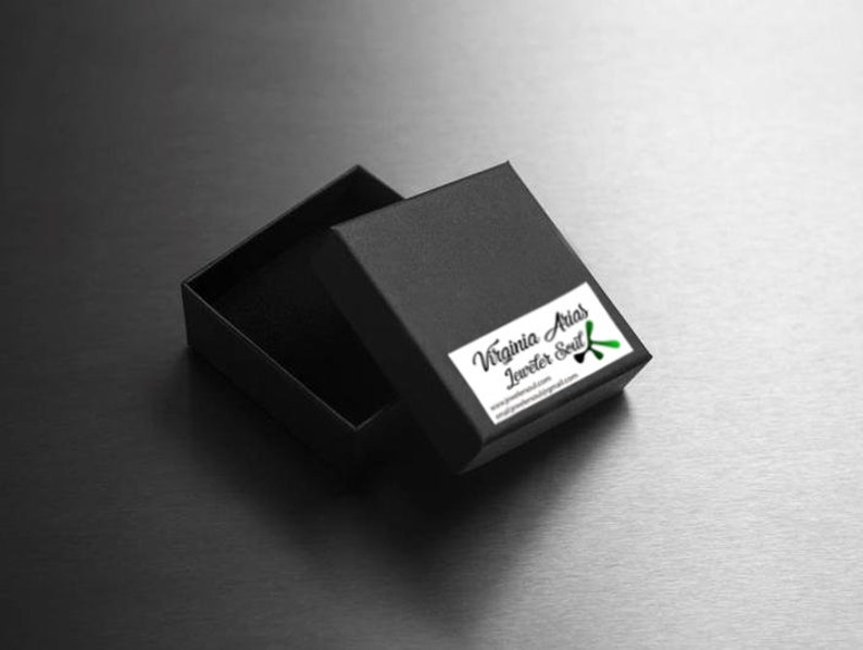 May include: A black jewelry box with a green and black logo that says "Virginia Arias Jeweler Soul" and the website address "virginiaariasjewelry.com".