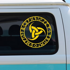 Könnte beinhalten: Ein türkisfarbener Vintage-Van mit weißem Dach und einem gelben Vinyl-Aufkleber mit einem Triquetra-Symbol, das von Runen umgeben ist, auf dem hinteren Fenster.