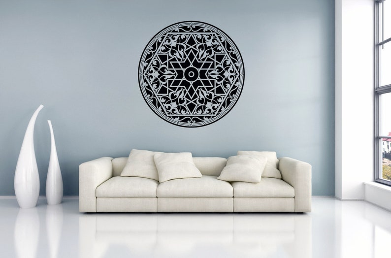 May include: A black and white mandala wall decal with intricate floral designs. The decal is applied to a light blue wall above a white couch.