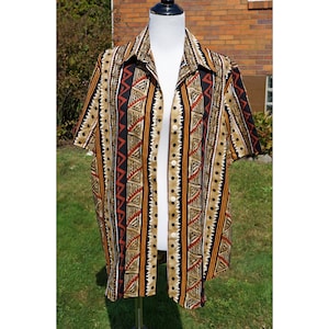May include: A short-sleeved button-down shirt with a geometric pattern in shades of brown, black, and red. The pattern features triangles, stripes, and dots.