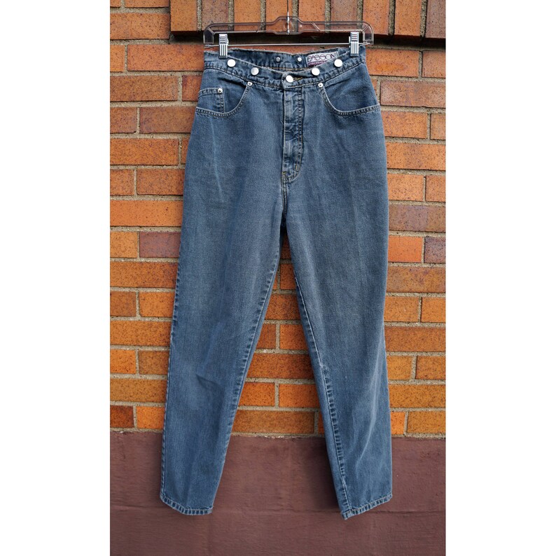 May include: A pair of high-waisted, blue denim jeans with a button fly and a double button closure at the waist.