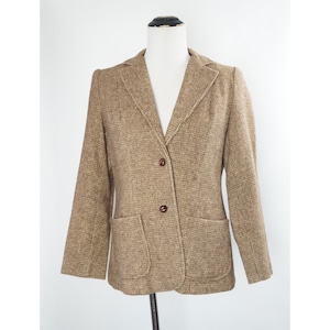 May include: A brown tweed blazer with a notched collar, two flap pockets, and three brown buttons.