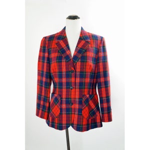 Puede incluir: Una chaqueta de cuadros rojos y azules con dos botones y dos bolsillos de solapa.