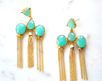 May include: A pair of gold earrings with turquoise gemstone accents and gold chain tassels.