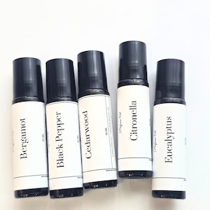 May include: Five perfume oil bottles with black caps and white labels. The labels read: Bergamot, Black Pepper, Cedarwood, Citronella, and Eucalyptus. Each bottle is 10 ml.