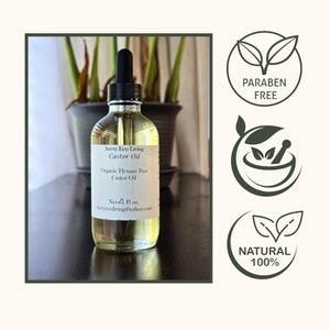K&ouml;nnte beinhalten: Eine klare Glasflasche mit einer Tropfpipette gef&uuml;llt mit gelbem Rizinus&ouml;l. Das Etikett lautet "Savvy Eco Living Castor Oil Organic Hexane Free Castor Oil Net 4 Fl oz. Savyecoliving@yahoo.com". Die Flasche ist von gr&uuml;nen Pflanzen umgeben. Das Bild enth&auml;lt auch drei gr&uuml;ne Symbole mit wei&szlig;em Text: "PARABEN FREE", "NATURAL 100%" und einen M&ouml;rser und St&ouml;&szlig;el.