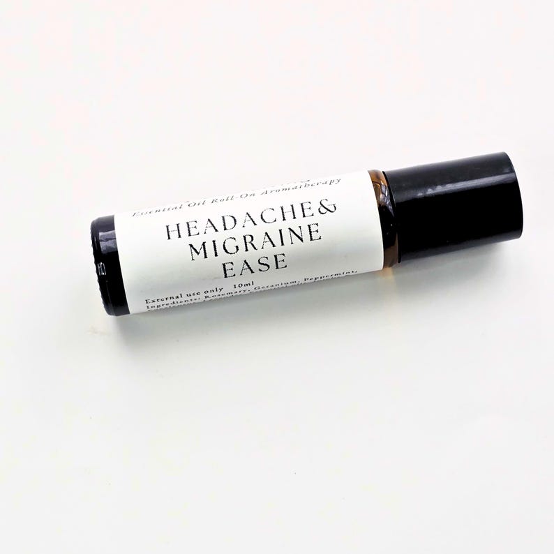 K&ouml;nnte beinhalten: Kleine, transparente Glas-Roll-on-Flasche f&uuml;r &auml;therische &Ouml;le mit schwarzem Deckel. Das Etikett tr&auml;gt den schwarzen Schriftzug "HEADACHE & MIGRAINE EASE". Enth&auml;lt 10 ml einer hellbraunen Fl&uuml;ssigkeit.