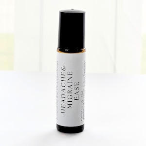 K&ouml;nnte beinhalten: Eine kleine Roll-on-Flasche mit &auml;therischem &Ouml;l, mit schwarzem Deckel und wei&szlig;em Etikett. Auf dem Etikett steht "Headache & Migraine Ease" in fetten schwarzen Buchstaben. Die Flasche enth&auml;lt 10 ml &auml;therische &Ouml;lmischung f&uuml;r die Aromatherapie.