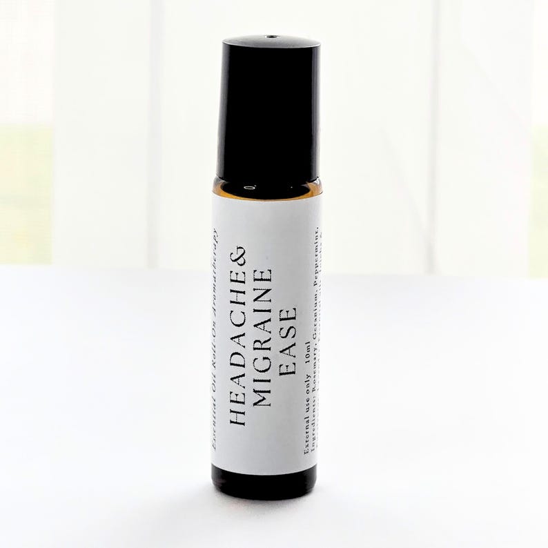 K&ouml;nnte beinhalten: Eine kleine Roll-on-Flasche mit &auml;therischem &Ouml;l, mit schwarzem Deckel und wei&szlig;em Etikett. Auf dem Etikett steht "Headache & Migraine Ease" in fetten schwarzen Buchstaben. Die Flasche enth&auml;lt 10 ml &auml;therische &Ouml;lmischung f&uuml;r die Aromatherapie.