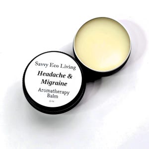 K&ouml;nnte beinhalten: Aromatherapie-Balsam f&uuml;r Kopfschmerzen und Migr&auml;ne in einer schwarzen Dose. Die Dose ist ge&ouml;ffnet und zeigt einen hellgelben Balsam. Das Etikett lautet "Savvy Eco Living Headache & Migraine Aromatherapy Balm .5 oz."