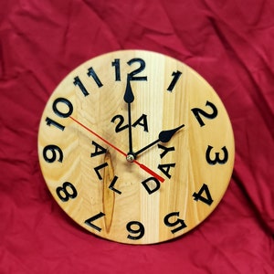 May include: A wooden clock with black numbers and hands. The clock face says "All Day" and has a red second hand.