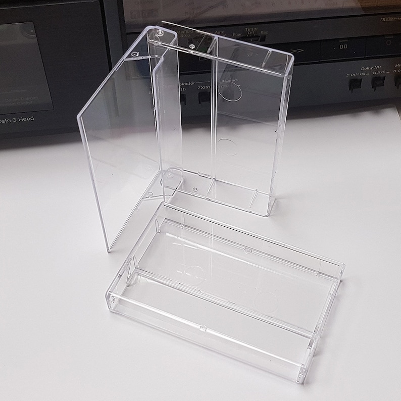 May include: Three clear plastic cassette tape cases. The cases are empty and are stacked on top of each other.