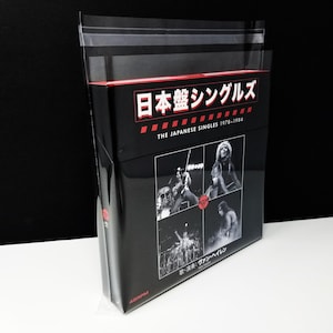 Pode incluir: Um box set preto intitulado "THE JAPANESE SINGLES 1978-1984" com texto japonês. A caixa apresenta imagens a preto e branco de uma banda. A caixa é embrulhada em plástico transparente. O texto "45RPM" é visível.