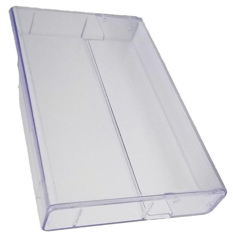 May include: A clear plastic case for storing cassette tapes. The case is empty and has a rectangular shape.