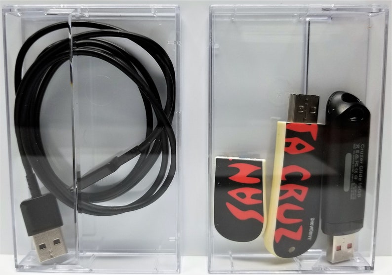May include: Two clear plastic cases containing various USB drives. The first case contains a black USB cable. The second case contains three USB drives: one black with "Cruzer Glide 16GB" text, one white with "Santa Cruz" text in red, and one black with a red flame design.