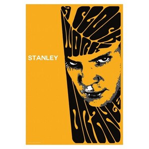May include: A poster with a yellow background featuring a stylized portrait of a person with intense eyes. The word "STANLEY" is printed in white. Black text in a swirling font reads "SEE WORK".
