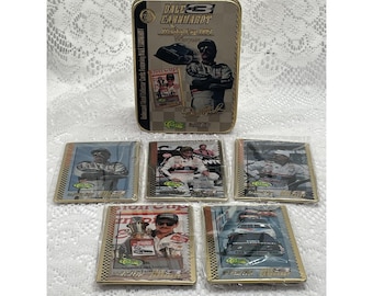 May include: A rectangular metal collector tin featuring Dale Earnhardt, the number 3, and Winston Cup 1994 Champion text. Five individual collector cards in clear plastic sleeves are arranged in front, each displaying racing imagery and text.