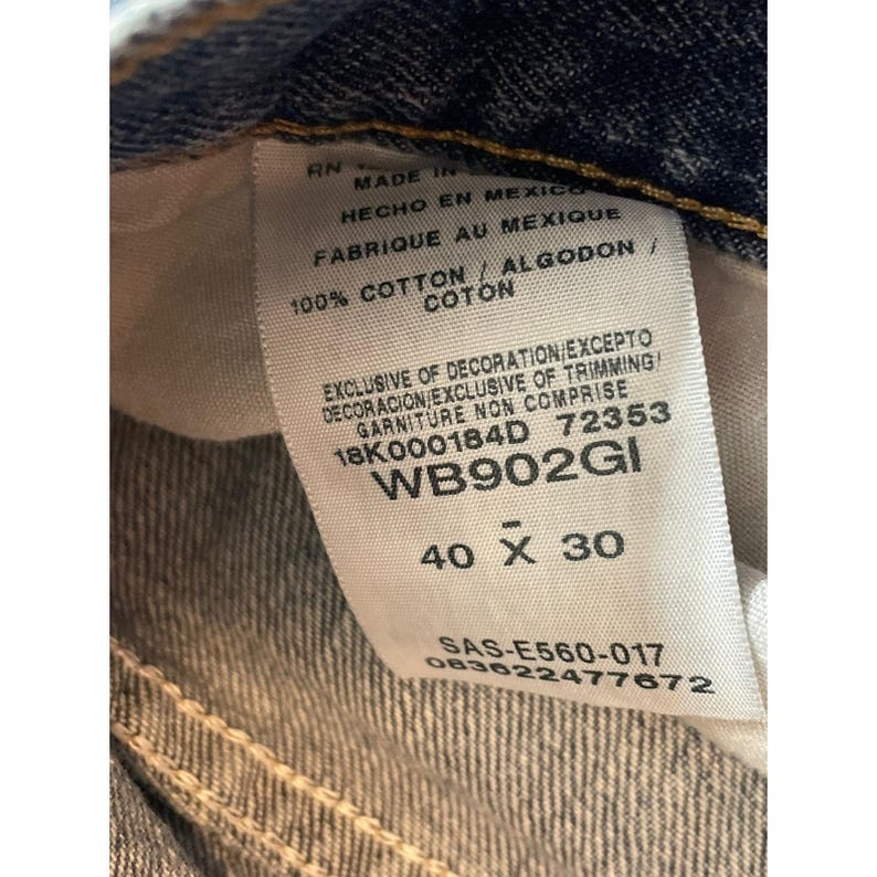 May include: Close-up of a denim jeans label. The label reads "MADE IN MEXICO" and "100% COTTON". The size is indicated as 40 x 30 inches. Other text includes style and care information.