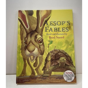 May include: A hardcover book titled "Aesop's Fables" with a vibrant illustration of a rabbit and a turtle. The cover is yellow with the title in large, bold letters. The book is part of the Dolly Parton Imagination Library.