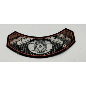 May include: A curved, embroidered patch featuring a detailed silver and black motorcycle engine graphic. The center circular emblem reads "HARLEY OWNERS GROUP 2007". The patch is outlined with a thick black border and a thin orange stitched accent line.