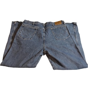May include: Light blue denim jeans with a classic five-pocket design. The jeans feature a straight leg cut and a brown leather patch on the back waistband. The back pockets have a stitched design.