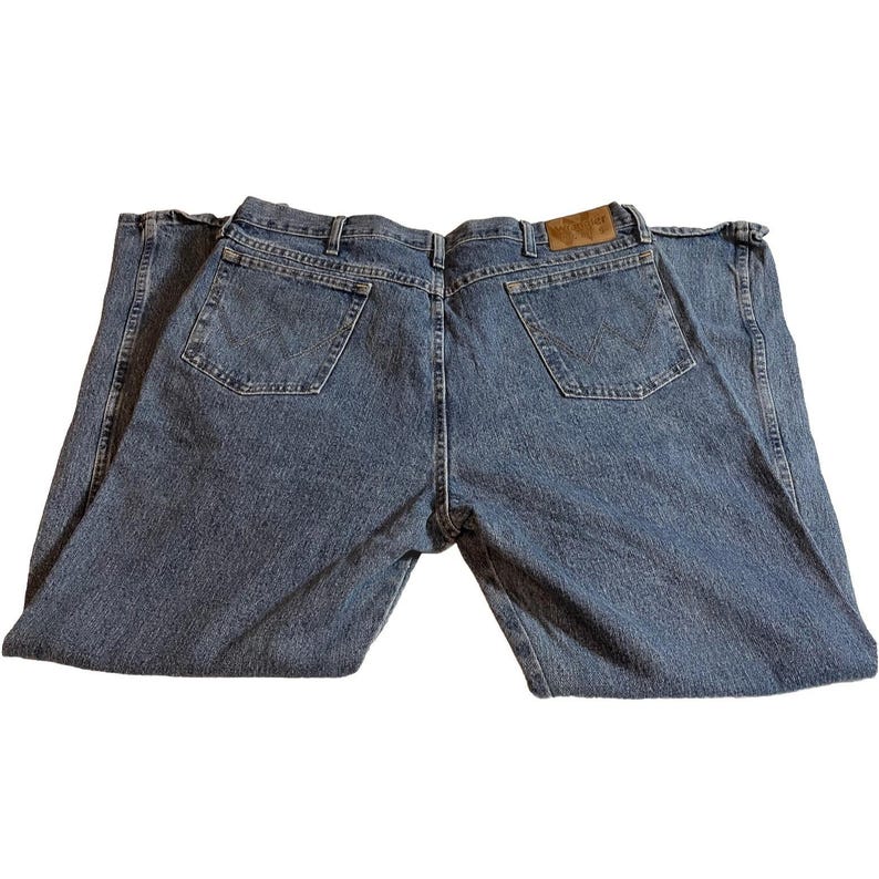 May include: Light blue denim jeans with a classic five-pocket design. The jeans feature a straight leg cut and a brown leather patch on the back waistband. The back pockets have a stitched design.