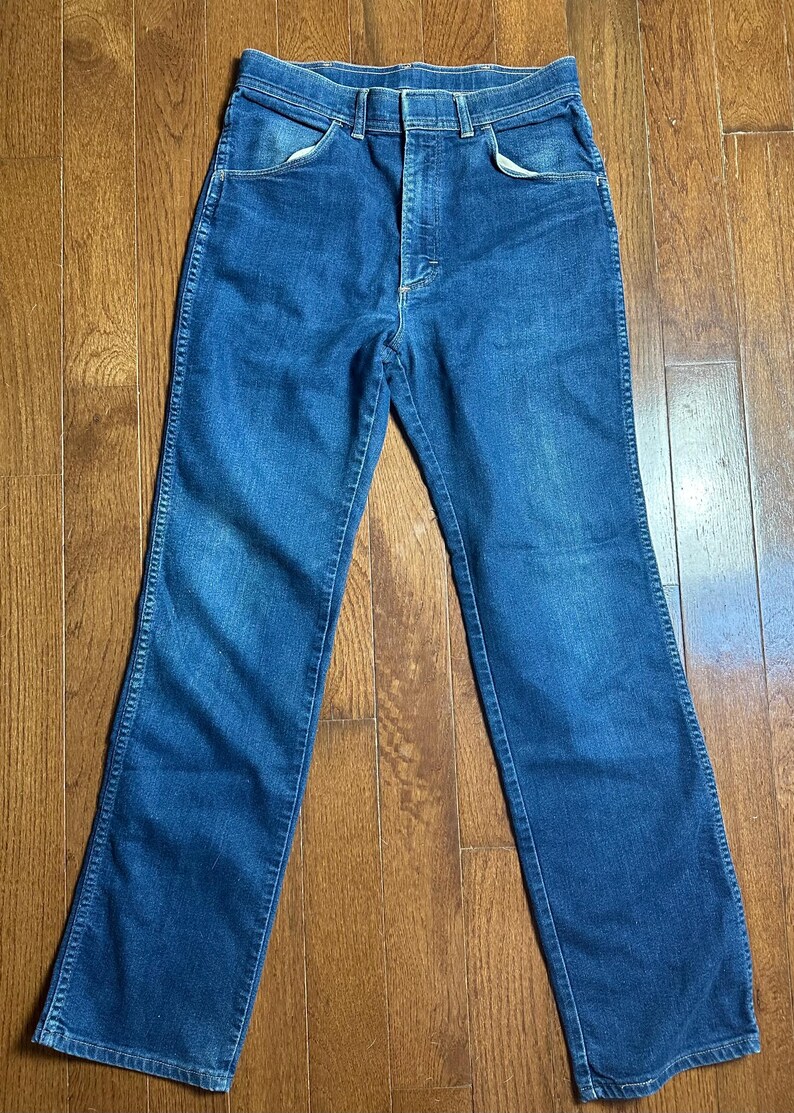 Puede incluir: Vaqueros de mezclilla azules con un dise&ntilde;o cl&aacute;sico de cinco bolsillos. Los vaqueros tienen cierre de bot&oacute;n y cremallera, trabillas para el cintur&oacute;n y un corte de pierna recto. El denim tiene un lavado medio con decoloraci&oacute;n sutil.