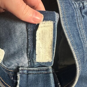Puede incluir: Primer plano de unos vaqueros azules con una etiqueta blanca. La etiqueta tiene texto y n&uacute;meros, incluyendo la talla 34W 34L. Los vaqueros est&aacute;n hechos de una tela de mezclilla duradera y presentan detalles de costura cl&aacute;sicos.