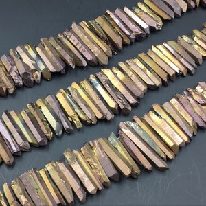 Puede incluir: Una hebra de puntas de cristal de cuarzo titanio iridiscente dorado y marrón. Las puntas miden aproximadamente 2,5-5 cm de largo y tienen un acabado natural y en bruto.