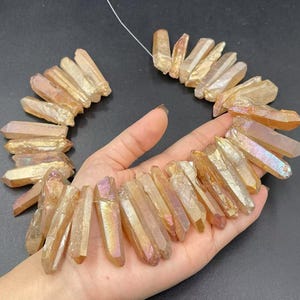 May include: A strand of iridescent, gold-toned quartz crystal points. The points are approximately 1-2 inches in length and have a natural, raw finish.