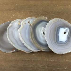 May include: Set of five agate coasters in shades of gray and white. Each coaster features a unique, naturally occurring pattern of concentric circles.