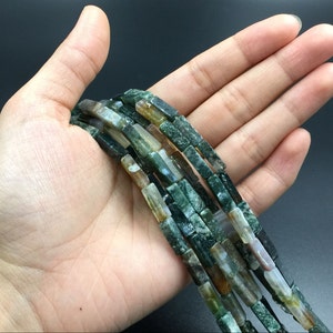 May include: A strand of green, brown, and white agate beads. The beads are rectangular and have a natural, polished finish.