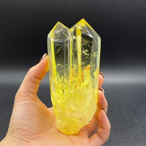 Op de afbeelding: Een dubbel geëindigd helder kwartskristal met een gele tint. Het kristal is ongeveer 12,5 cm hoog en heeft een natuurlijke, ruwe uitstraling.