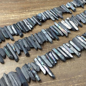 May include: A strand of black iridescent quartz crystal points, also known as black titanium quartz, arranged in a staggered pattern. The crystals are raw and have a natural, rough texture.