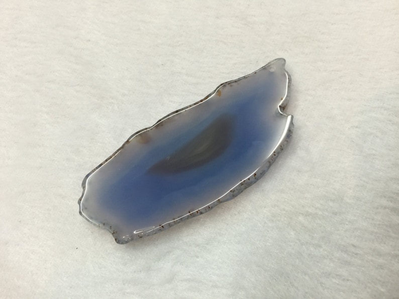 May include: A light blue agate slice with a white and grey banded pattern. The agate is smooth and polished, with a natural, irregular shape.