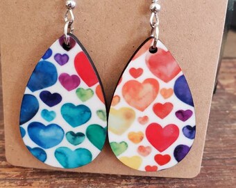 Los corazones de arco iris cuelgan pendientes. Mes del Orgullo. Regalos para todos. LGBTQ. Ama a todos.