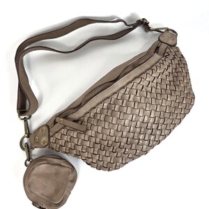 Puede incluir: Un bolso de cintura de cuero tejido de color topo con un peque&ntilde;o monedero a juego adjunto. El bolso tiene una correa larga ajustable y un cierre de cremallera. El bolso de cintura est&aacute; hecho de cuero suave y flexible.