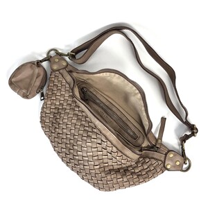 Puede incluir: Un bolso cruzado tejido de color topo con una peque&ntilde;a bolsa a juego. El bolso tiene una correa larga y ajustable y un compartimento principal con cremallera. El forro interior es de un tono beige m&aacute;s claro. El bolso est&aacute; hecho de un material suave.