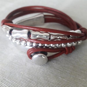 May include: A brown leather wrap bracelet with silver beads and metal accents.