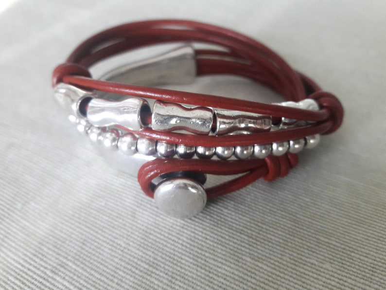 May include: A brown leather wrap bracelet with silver beads and metal accents.
